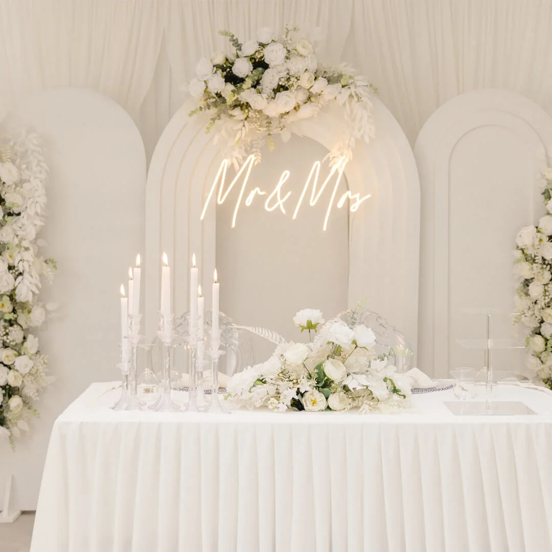 Weiße Hochzeitstafel mit Blumen und stimmungsvoller Beleuchtung